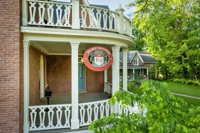 a front porch of a house with a white railing at Manoir Sweetsburg in Cowansville
