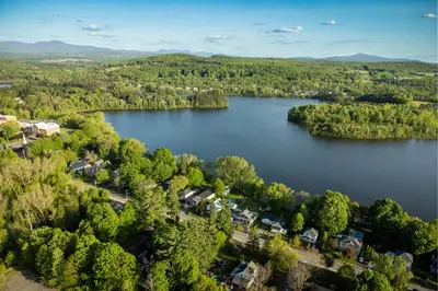 an aerial view of a lake with houses and trees at Manoir Sweetsburg in Cowansville