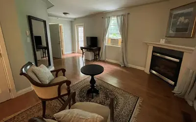 a living room with a fireplace and a table and chairs at Manoir Sweetsburg in Cowansville