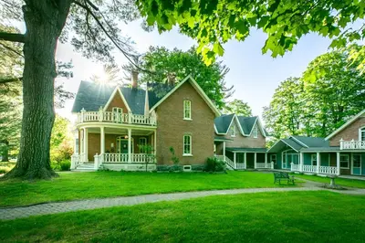 a large brick house with a large yard at Manoir Sweetsburg in Cowansville