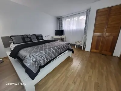 a bedroom with a large bed and a wooden floor at CosyRoom in Brossard