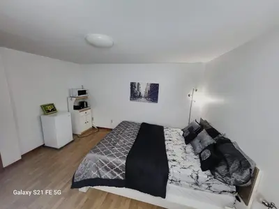 a bedroom with a bed with black and gray pillows at CosyRoom in Brossard