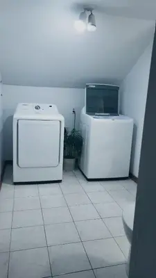 a room with a microwave and a computer on the floor at CosyRoom in Brossard