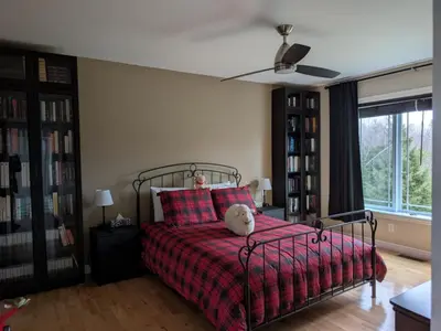 a bedroom with a bed with a teddy bear on it at Maison aux Mésanges in Waterloo