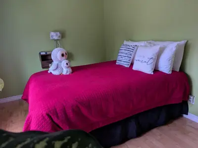 a teddy bear sitting on top of a pink bed at Maison aux Mésanges in Waterloo