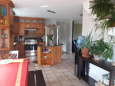 a kitchen with wooden cabinets and a stainless steel refrigerator at Maison aux Mésanges in Waterloo