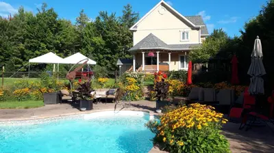 a house with a swimming pool in front of a house at Maison aux Mésanges in Waterloo