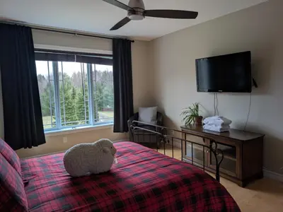 a bedroom with a teddy bear sitting on a bed at Maison aux Mésanges in Waterloo