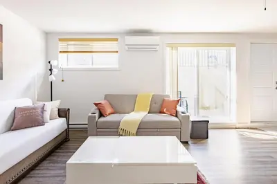 a living room with two couches and a coffee table at Logement neuf, spacieux in Longueuil