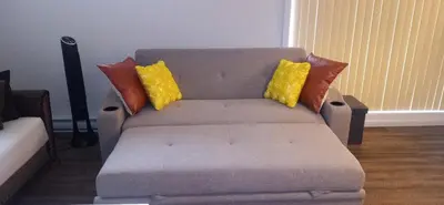 a couch with pillows on it in a living room at Logement neuf, spacieux in Longueuil