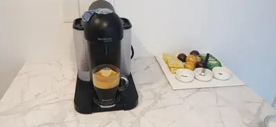 a coffee maker sitting on a counter with a drink at Logement neuf, spacieux in Longueuil