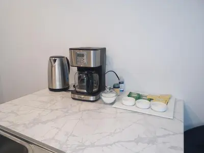a counter with a coffeemaker and a coffee maker at Logement neuf, spacieux in Longueuil