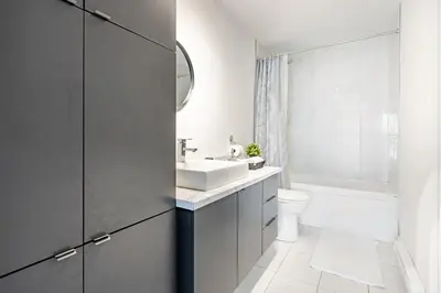 a white bathroom with a sink and a toilet at Logement neuf, spacieux in Longueuil