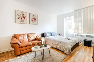 a bedroom with a couch and a bed and a table at Lumière et Propreté à McGill parking gratuit in Montréal