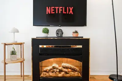 a tv above a fireplace with a television above it at Lumière et Propreté à McGill parking gratuit in Montréal