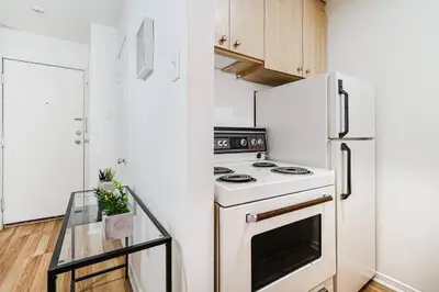 a white kitchen with a stove and a refrigerator at Lumière et Propreté à McGill parking gratuit in Montréal