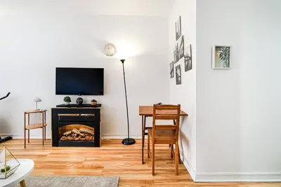 a living room with a fireplace and a table and a television at Lumière et Propreté à McGill parking gratuit in Montréal