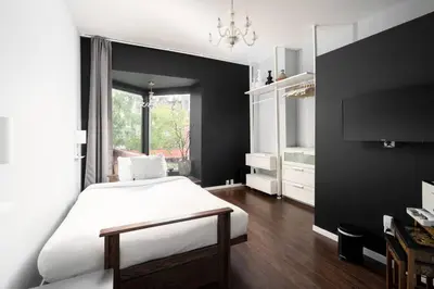 a bedroom with a white bed and a black wall at Two bedroom duplex in Plateau Mont-Royal district in Montréal