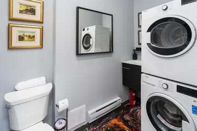 a bathroom with a washing machine and a washer at Two bedroom duplex in Plateau Mont-Royal district in Montréal