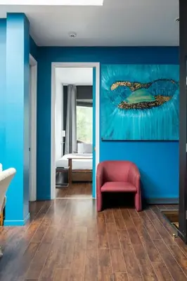 a living room with a red chair and a blue wall at Two bedroom duplex in Plateau Mont-Royal district in Montréal