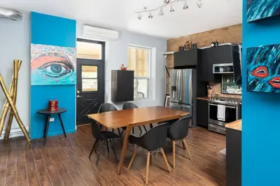 a kitchen with a wooden table and black appliances at Two bedroom duplex in Plateau Mont-Royal district in Montréal