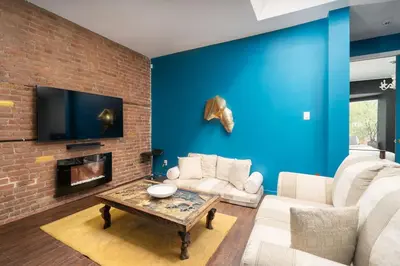 a living room with blue walls and a brick wall at Two bedroom duplex in Plateau Mont-Royal district in Montréal