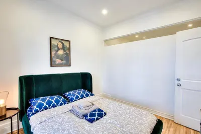 a bedroom with a bed with blue pillows on it at Montreal Vacation & Attractions Home by Downtown & Plateau in Montréal
