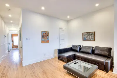 a living room with a leather couch and a table at Montreal Vacation & Attractions Home by Downtown & Plateau in Montréal