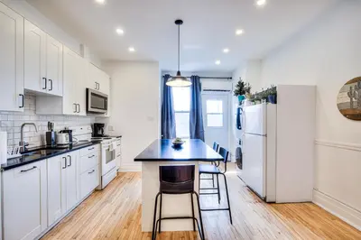a kitchen with white cabinets and a blue counter top at Montreal Vacation & Attractions Home by Downtown & Plateau in Montréal