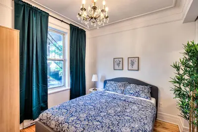 a bedroom with a bed and a chandelier at Montreal Vacation & Attractions Home by Downtown & Plateau in Montréal