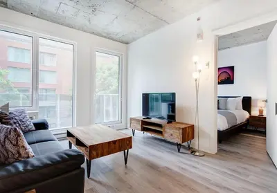 a living room with a couch and a tv and a bed at Montreal rent in Montréal