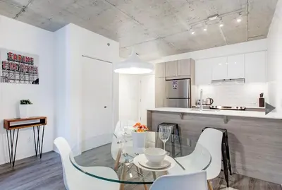 a kitchen with a glass table and white chairs at Montreal rent in Montréal