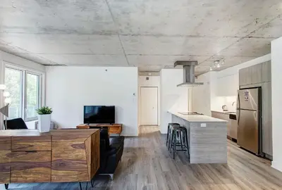 a kitchen and living room with white walls and wood floors at Montreal rent in Montréal