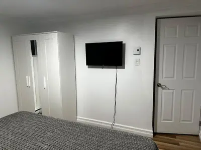 a bedroom with a bed and a flat screen tv on the wall at Appartement en étage in Mascouche