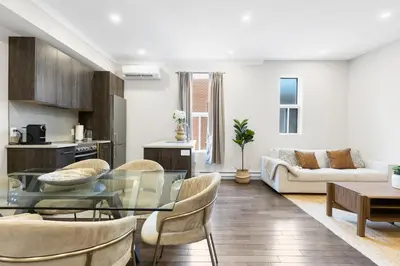 a living room with a glass table and chairs at The Parc Mile End ApartHotel in Montréal