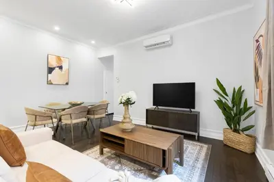 a living room with a couch and a tv and a table at The Parc Mile End ApartHotel in Montréal