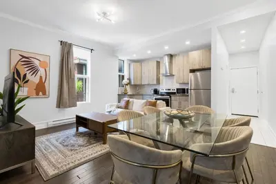 a kitchen and living room with a glass table and chairs at The Parc Mile End ApartHotel in Montréal
