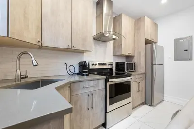 a kitchen with wooden cabinets and stainless steel appliances at The Parc Mile End ApartHotel in Montréal