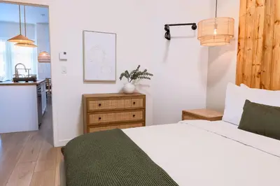 a bedroom with a white bed and a kitchen at #1 - Luxurious 2Bds - Self Check in - Plateau - St-Denis - AC - TV in Montréal