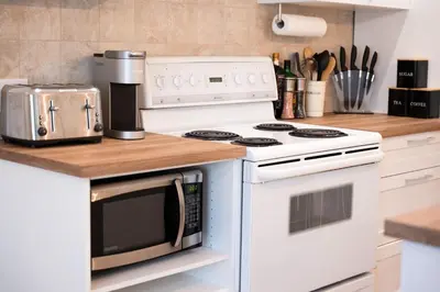 a kitchen with a white stove top oven next to a counter at #1 - Luxurious 2Bds - Self Check in - Plateau - St-Denis - AC - TV in Montréal