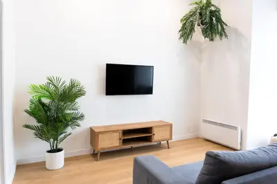 a living room with a tv on a white wall at #1 - Luxurious 2Bds - Self Check in - Plateau - St-Denis - AC - TV in Montréal