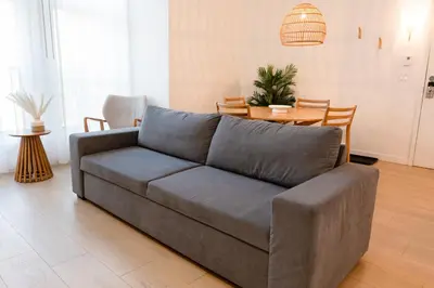 a gray couch in a living room with a table at #1 - Luxurious 2Bds - Self Check in - Plateau - St-Denis - AC - TV in Montréal