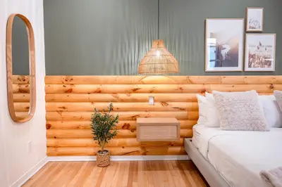 a bedroom with a bed with a wooden wall at #2 - Cozy Studio - Self Check in - Plateau - St-Denis - AC - TV in Montréal
