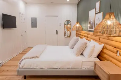 a bedroom with a large bed with a wooden headboard at #2 - Cozy Studio - Self Check in - Plateau - St-Denis - AC - TV in Montréal