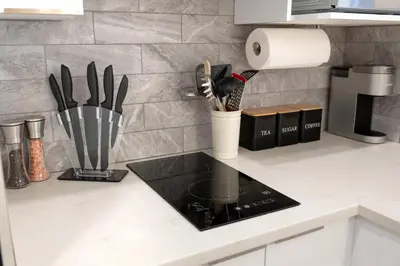 a kitchen counter with a cup of utensils at #2 - Cozy Studio - Self Check in - Plateau - St-Denis - AC - TV in Montréal