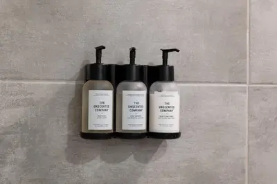 three bottles of moisturizers sitting on a tile wall at #2 - Cozy Studio - Self Check in - Plateau - St-Denis - AC - TV in Montréal
