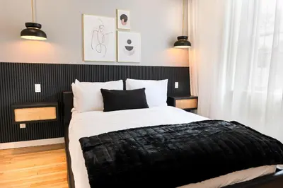 a black and white bedroom with a large bed at #3 - Chic Studio - Self Check in - Plateau - St-Denis - AC - TV in Montréal
