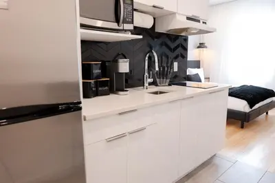 a kitchen with white cabinets and a microwave at #3 - Chic Studio - Self Check in - Plateau - St-Denis - AC - TV in Montréal