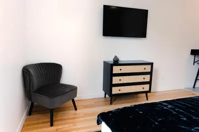 a bedroom with a chair and a dresser with a television at #3 - Chic Studio - Self Check in - Plateau - St-Denis - AC - TV in Montréal