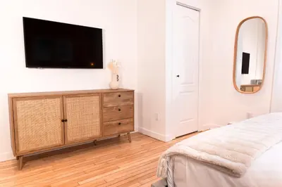 a bedroom with a dresser with a tv on a wall at #4 - Quaint Studio - Self Check in - Plateau - St-Denis - AC - TV in Montréal